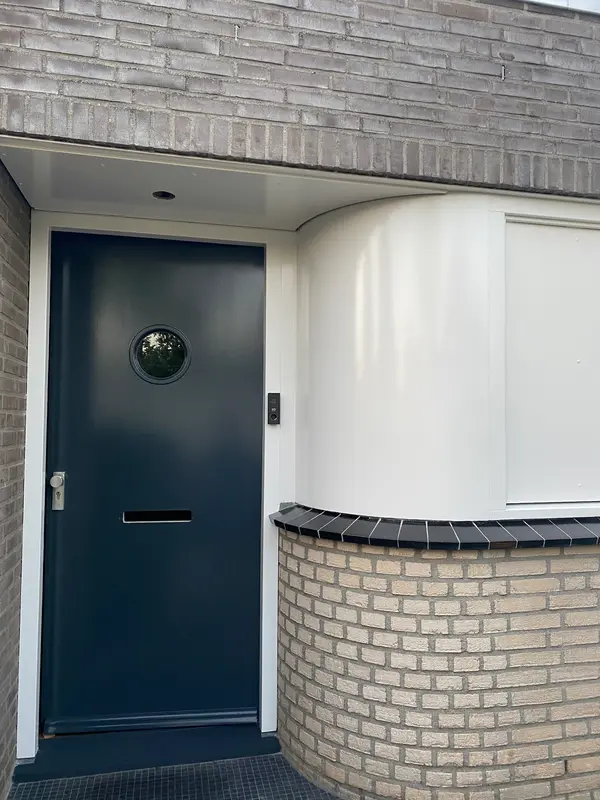 Donkerblauwe voordeur met witte omlijsting